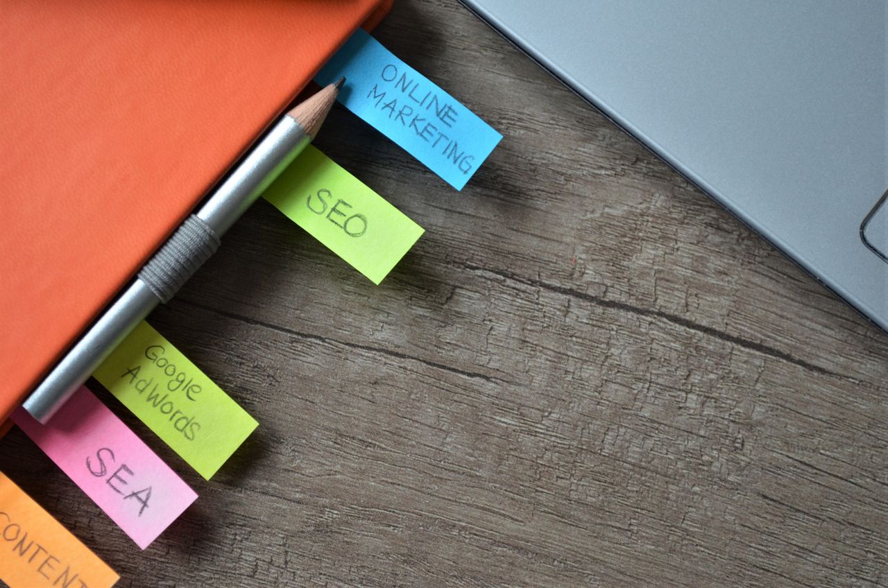 Vue rapprochée d’un planificateur de stratégie SEO avec des notes adhésives colorées et un crayon sur un carnet.